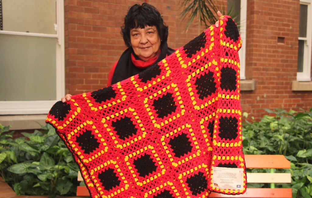 Photograph of Ursula Swan with a quilt